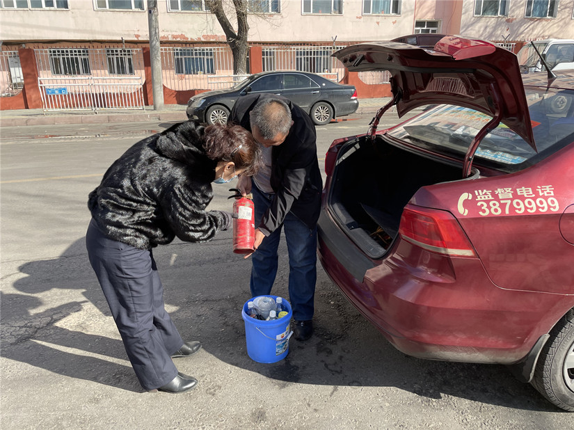 圖為：運(yùn)輸公司管理人員對(duì)出租車上滅火器的檢查_副本.jpg
